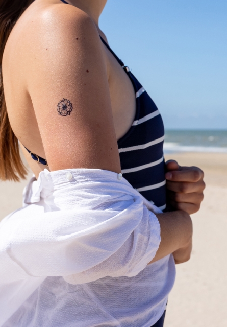 Femme à la plage arborant un tatouage éphémère de Bernard Forever