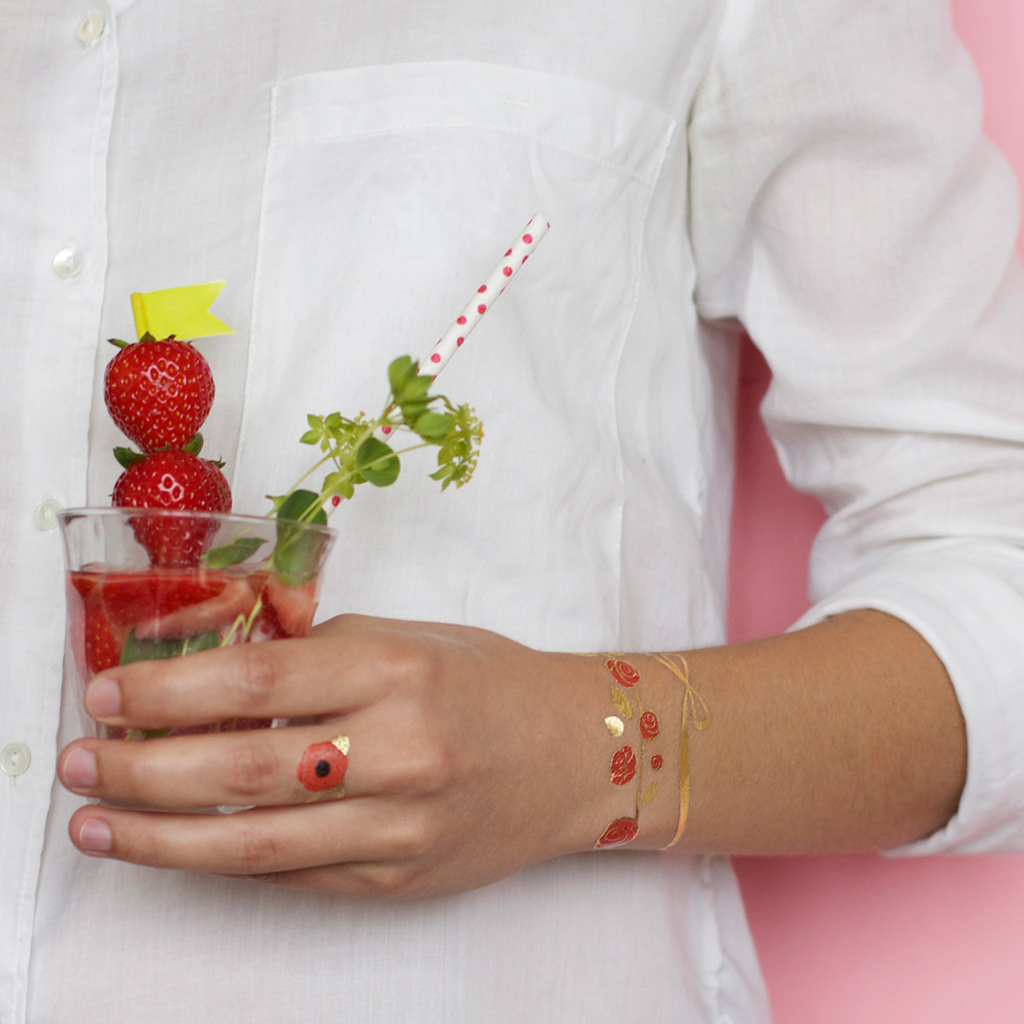 Temporary tattoo by artist Anne-Claire bracelet of roses applied to a woman's wrist