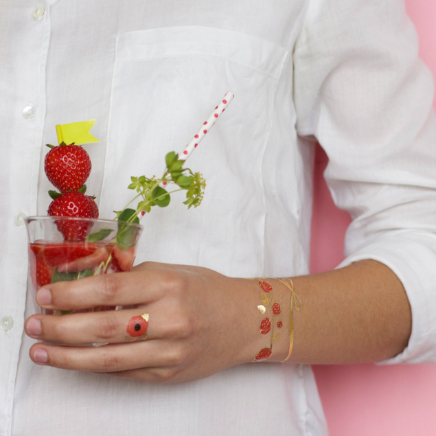 Tatouage éphémère de l'artiste Anne-Claire bracelet de roses et bague florale appliqués sur le poignet et majeur d'une femme