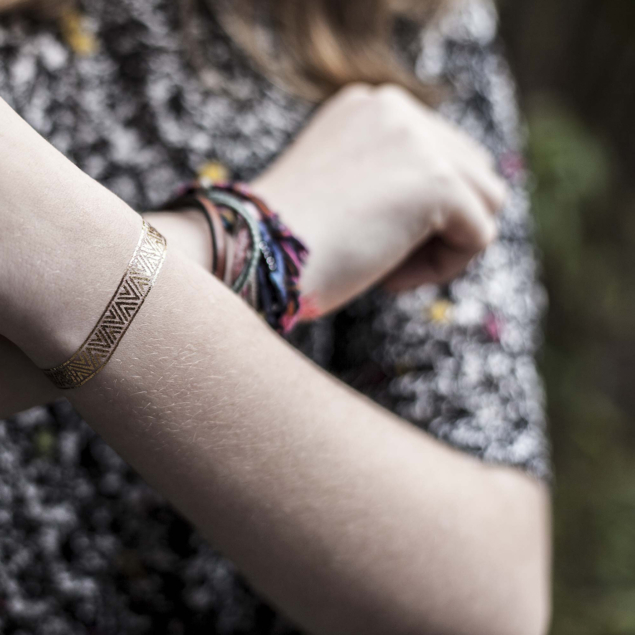 tatouage temporaire bracelet doré de la planche "la ruée vers l'or" appliqué sur le poignet d'une femme