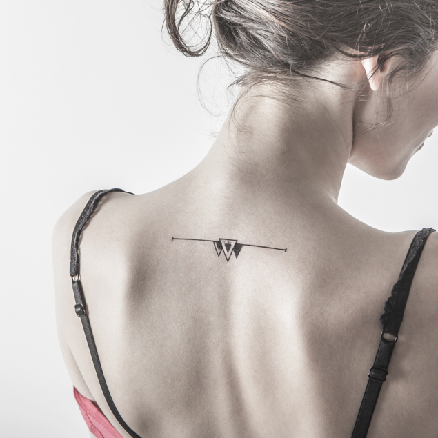 Tatouage temporaire triangles noirs "angle mort" appliqué sur le dos d'une femme