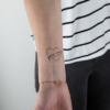 Temporary black tattoo woman with phone from the board "violence and love" applied on a woman's wrist