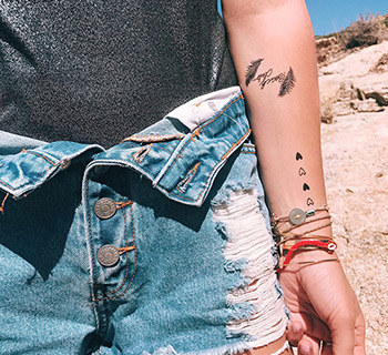 Tatouages temporaires noirs appliqués sur l'avant bras d'une femme          
