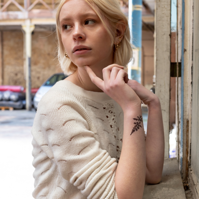 Black flower temporary tattoo of the "monocotyledon" board applied on a woman's wrist