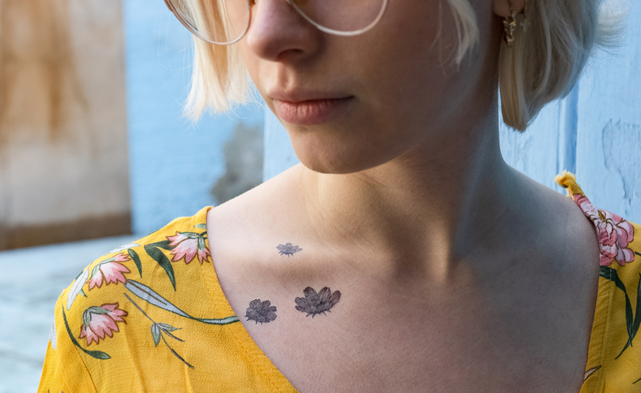 Tatouages temporaires fleurs noires de la planche "monocotylédone" appliqués sur la clavicule d'une femme