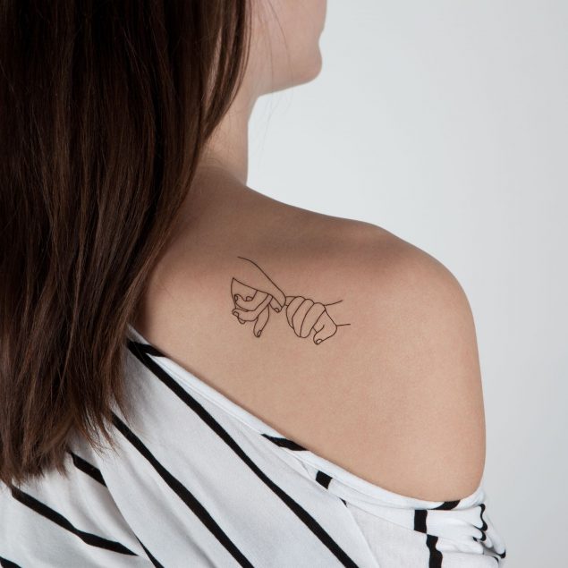 Tatouage temporaire noir mains en line art de la planche "tattoo c'que j'aime" appliqué sur l'épaule d'une femme