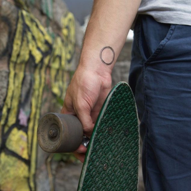 Tatouage temporaire cercle noir de la planche "daily minimal" appliqué sur le poignet d'un homme