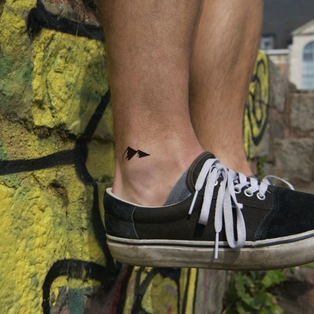 Tatouage temporaire montagnes noires de la planche "daily minimal" appliqué sur la cheville d'un homme