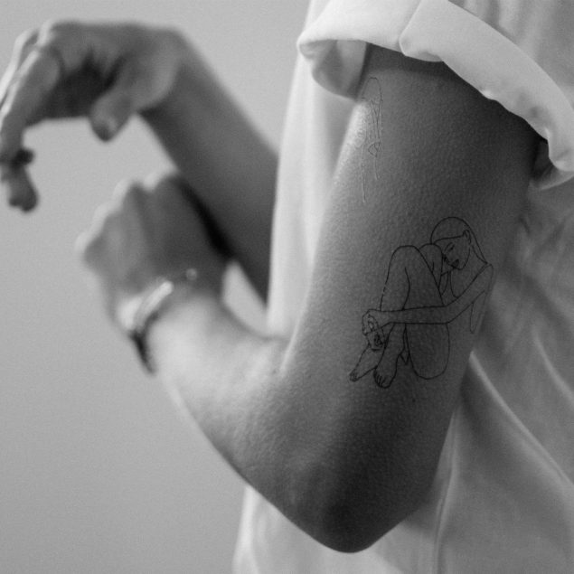 tatouage temporaire silhouette femme noir en line art de la planche "lazy afternoon" appliqué sur le bras d'une femme