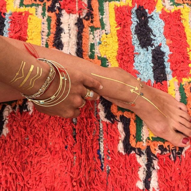 tatouages temporaires bracelets dorés de la planche "les p'tits joncs appliqués sur le poignet et le pied d'une femme