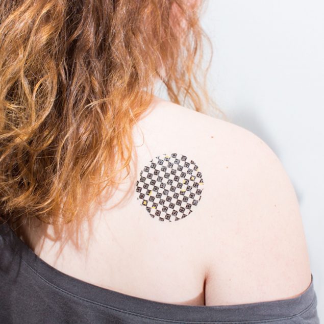 tatouage temporaire géométrique noir de la planche "illusion" appliqué sur l'épaule d'une femme