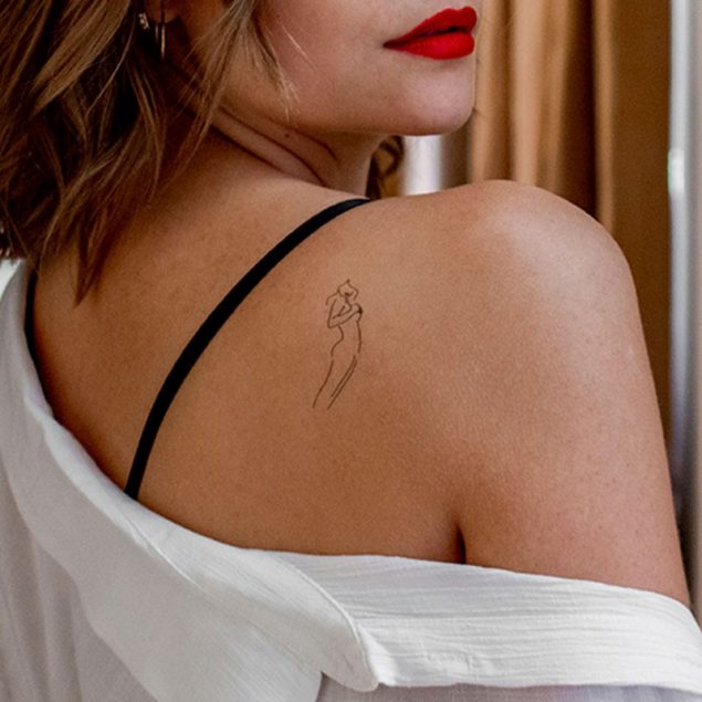 Tatouage temporaire noir silhouette femme de la planche "les lèvres rouges" appliqué sur l'épaule d'une femme