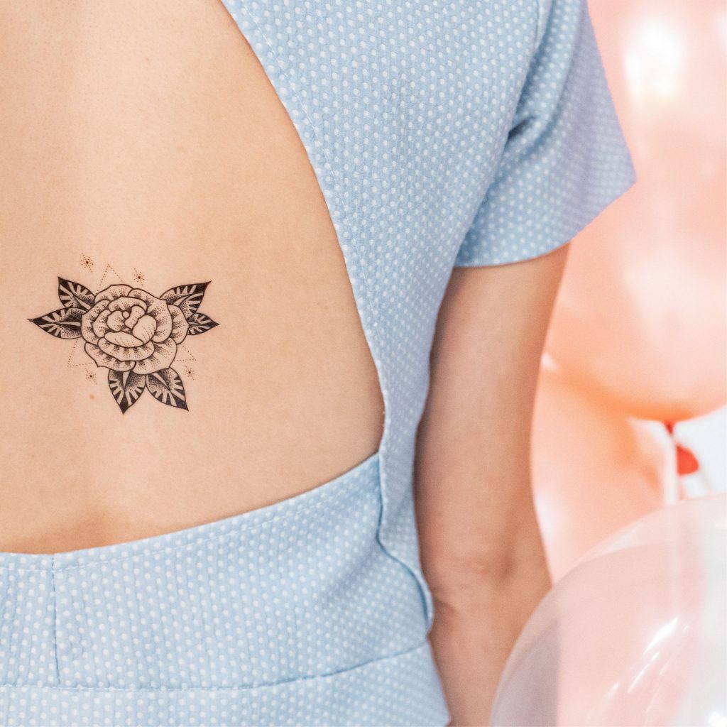Tatouage temporaire rose noire de la planche "cosmic cat" appliqué sur le dos d'une femme