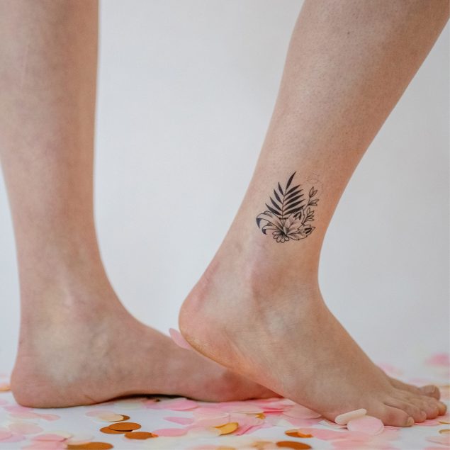 Tatouage temporaire fleur noire de la planche "cosmic cat" appliqué sur la cheville d'une femme