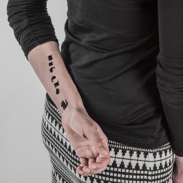Tatouages temporaires chats noirs de la planche "chat alors" appliqués sur le bras d'une femme
