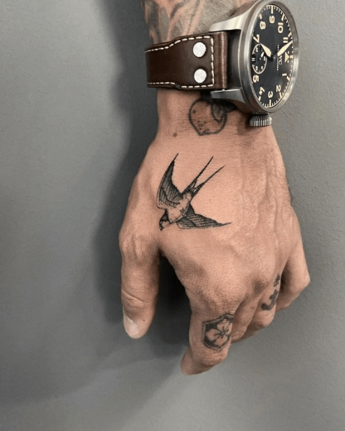 tatouage tendance pour homme avec une colombe tatouée sur la main 