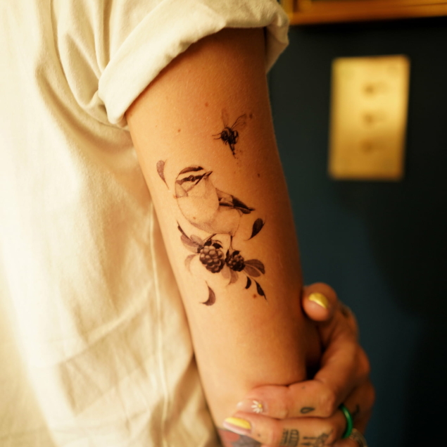 Temporary bird tattoo on a woman's arm